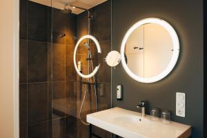 VILOTEL - Hotel & Restaurant في أوبركوخن: حمام مع حوض ومرآة
