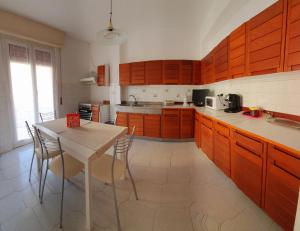 uma cozinha com armários de madeira e uma mesa com cadeiras em casa maya em Recco