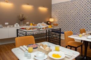 a breakfast room with a table with food on it at Bacharéis Charming House in Figueira da Foz