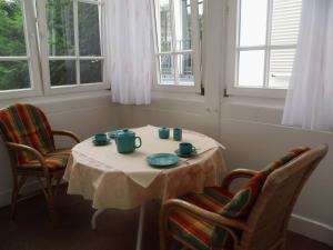 una mesa en una habitación con 2 sillas y una mesa con tazas en Apartments Haus Eintracht Sellin, en Ostseebad Sellin