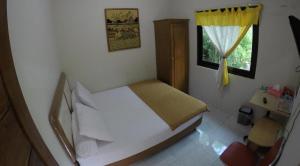 a small bedroom with a bed and a window at Sabana Homestay in Yogyakarta