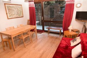salon z drewnianym stołem, stołem i kanapą w obiekcie JANDRI 4 Appartement 6 personnes -38860 Les 2 Alpes - Pied des pistes w mieście Les Deux Alpes