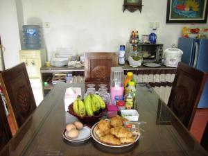 a kitchen table with a bowl of bread and bananas at Sabana Homestay in Yogyakarta