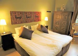 a bedroom with a large bed with white sheets and pillows at Villa Maria Garden Cottages, Helsingborg in Helsingborg