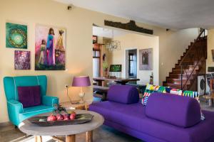 a living room with a purple couch and a table at Beachfront Villa Meliti in Ágios Matthaíos