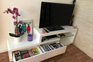 un centro de entretenimiento blanco con televisión. en Nice Studio Near Mickey, Disneyland at 5mn, en Montévrain