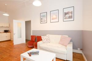 ein Wohnzimmer mit einem weißen Sofa und einem Tisch in der Unterkunft Issoire centre, T2 Bergère avec parking in Issoire