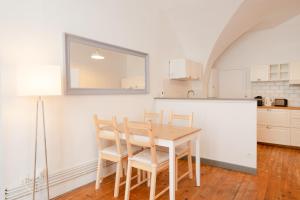 eine Küche mit einem Tisch und Stühlen sowie einem Kühlschrank in der Unterkunft Issoire centre, T2 Bergère avec parking in Issoire