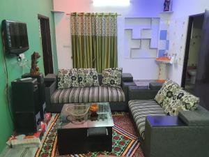- un salon avec un canapé et une télévision dans l'établissement Traverse Suite, à Jaipur
