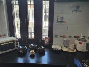 une cuisine avec un comptoir avec des casseroles et un four micro-ondes dans l'établissement Traverse Suite, à Jaipur