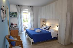 sypialnia z niebiesko-białym łóżkiem i krzesłem w obiekcie B&B LaMarina w mieście Alghero