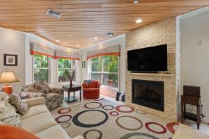 a living room with a fireplace and a flat screen tv at Siesta Key - Miramar 1216 in Siesta Key