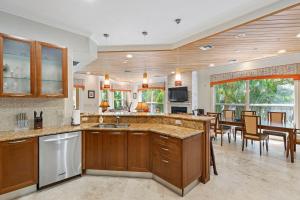 a kitchen with wooden cabinets and a dining room at Siesta Key - Miramar 1216 in Siesta Key