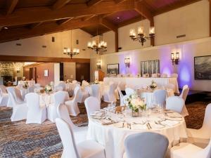 a banquet hall with white tables and white chairs at Fairmont Jasper Park Lodge in Jasper +291 photos