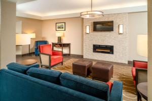 salon z niebieską kanapą i kominkiem w obiekcie Comfort Inn & Suites w mieście Grundy
