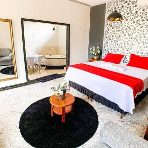 a hotel room with a large bed and a table at Pousada Grande Rio in Pirapora