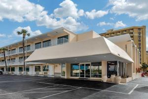 un bâtiment avec un auvent blanc dans un parking dans l'établissement Quality Inn Daytona Beach Oceanfront, à Daytona Beach