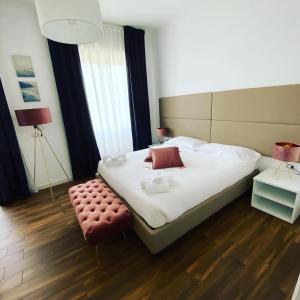 ein Schlafzimmer mit einem großen Bett mit einem roten Stuhl in der Unterkunft Mapi’s Rooms in Cagliari
