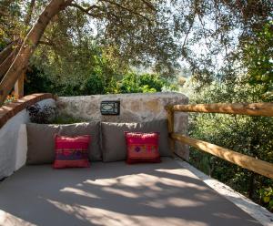 a bench with two pillows sitting under a tree at Room in BB - Exclusive and Romantic Boutique Hotel in Fethiye