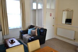 uma sala de estar com um sofá de couro preto e uma mesa em Seam Terrace - Home from Home em Sittingbourne