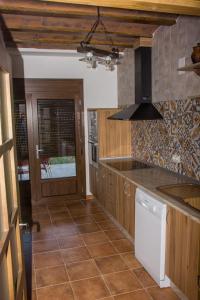 a kitchen with wooden cabinets and a counter top at Casa Rural Consuelo in Torralba