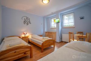 シュクラルスカ・ポレンバにあるGospoda Graniczna Bombaj Jakuszyceのベッドルーム1室(ベッド2台、壁掛けテレビ付)