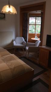 a bedroom with a bed and a table and a window at Pension - Gästehaus Zum Pfälzerwald in Hinterweidenthal