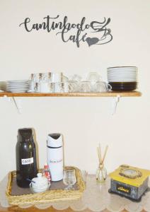 a shelf with a coffee maker and dishes on a table at Hospedaria Solar De Morretes in Morretes