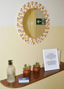 a mirror on top of a shelf with some plants at Hospedaria Solar De Morretes in Morretes