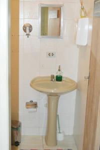 a bathroom with a sink and a mirror at Hospedaria Solar De Morretes in Morretes