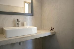 a bathroom with a white sink and a mirror at Notus Villa in Chorto