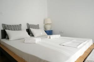 a large white bed with white sheets and pillows at Notus Villa in Chorto