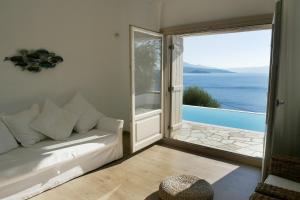 a living room with a couch and a large window at Notus Villa in Chorto