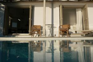 two chairs and a table next to a swimming pool at Notus Villa in Chorto