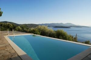a large swimming pool with a view of the water at Notus Villa in Chorto