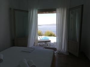 a bedroom with a bed and a view of a pool at Notus Villa in Chorto
