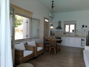 a kitchen and dining room with wicker chairs and a table at Notus Villa in Chorto