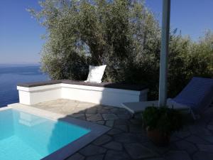 a swimming pool next to two chairs next to at Notus Villa in Chorto