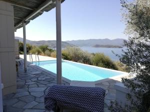a swimming pool with a table and a chair next to it at Notus Villa in Chorto