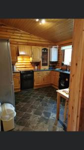 a kitchen with wooden cabinets and a black appliance at Rock Lodge in Alnwick