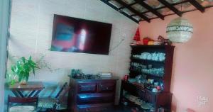 a room with a table and a television on a wall at GO Hotelaria in Búzios