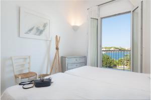 a bedroom with a white bed and a window at Villa Can Marilla in Portocolom +52 photos