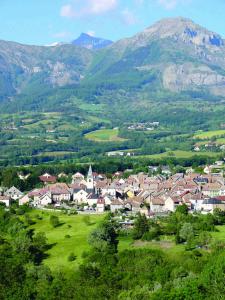 a village in a valley with mountains in the background at Honey Moon in Saint-Bonnet-en-Champsaur