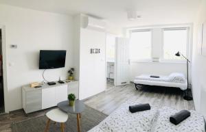 a white living room with a couch and a table at Central Apartments in Veszprém