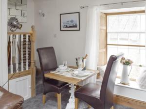 a dining room with a table and two chairs at Upside Down Cottage in Richmond +3 photos