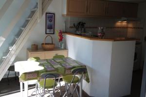 a kitchen with a table and chairs and a counter at Pavillon dans résidence avec piscine au cœur d'Argeles sur mer- 6PMER120 in Plage dʼArgelès