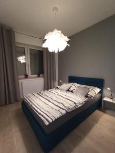 1 dormitorio con 1 cama grande y lámpara de araña en Apartament Września II, en Września