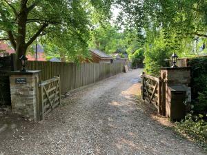 a dirt road with a fence and a gate at The Little Barn - Self Catering Holiday Accommodation in Hindhead