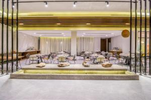 um átrio com mesas e cadeiras e uma grande fonte em Ewaa Express Hotel - Tabuk em Tabuk