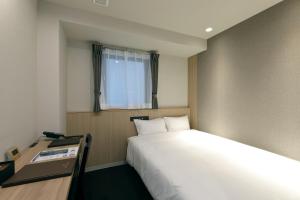 Een bed of bedden in een kamer bij At Inn Hotel Toyotashi Eki